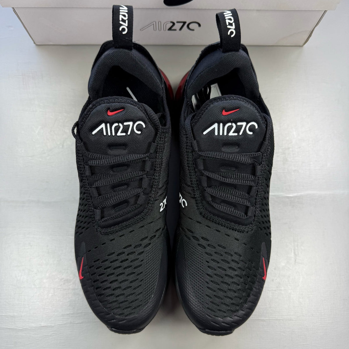 Nike Air Max 270 black trainers with university red accents and white sole.