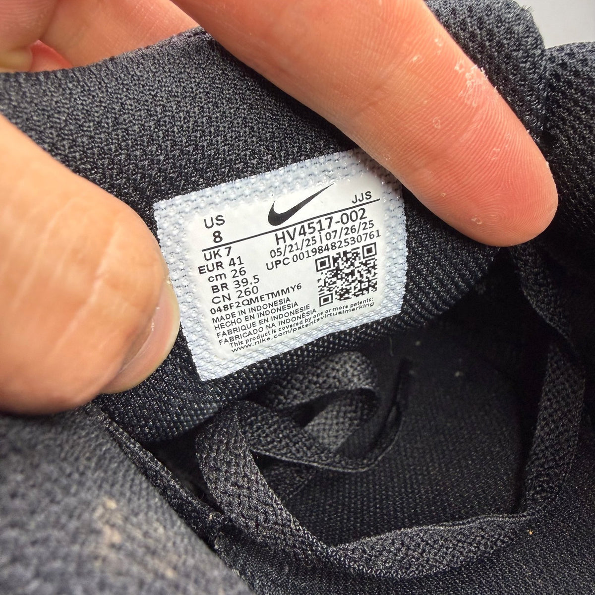 Nike Air Max 90 Premium black trainers with silver reflective accents and logo details.