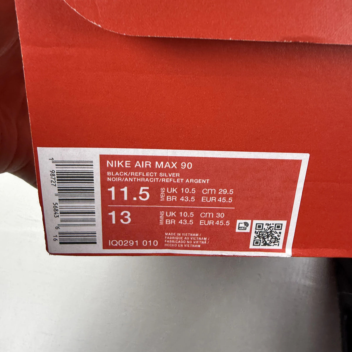 Nike Air Max 90 black sneaker with reflective silver accents and logo details.