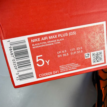 Nike Air Max Plus TN black trainers with orange accents and signature logo details.