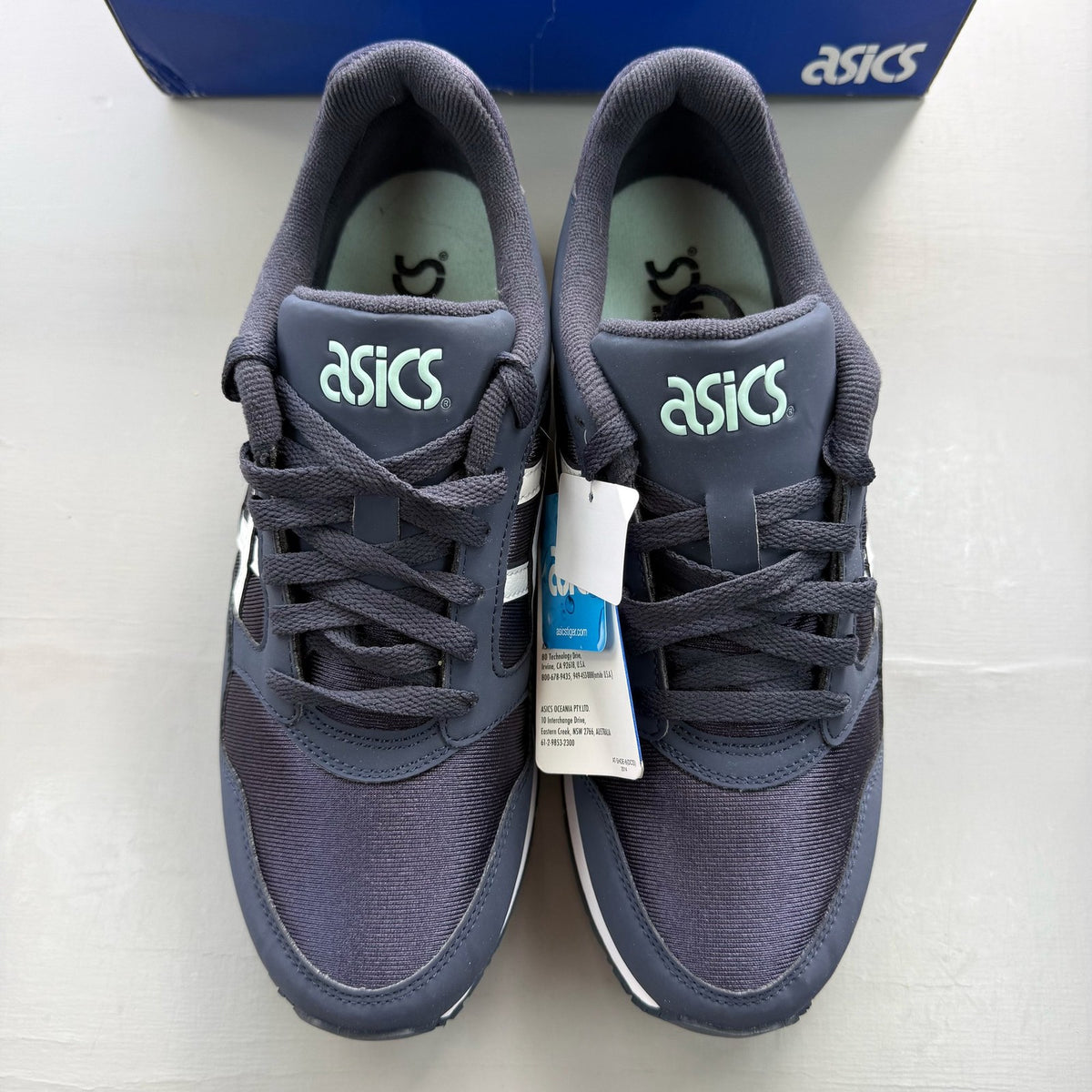 ASICS blue trainers with white accents and logo detail on the side.