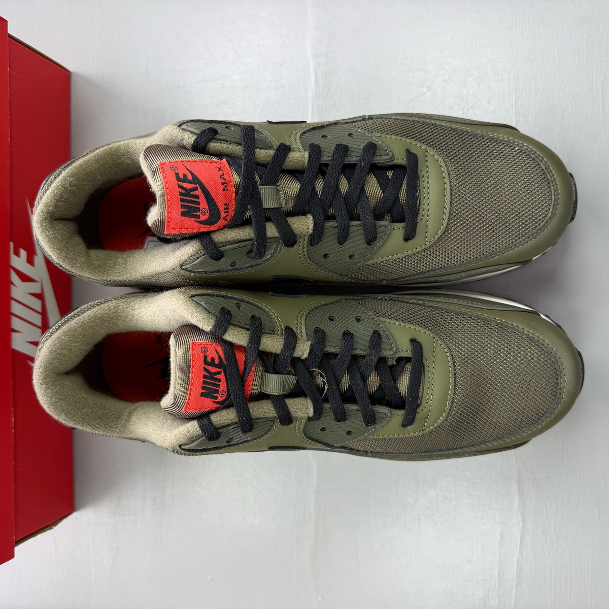 Nike Air Max 90 green trainers with black accents and classic logo detail.