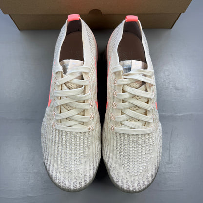 Nike trainers light cream pink Flyknit material with Air cushioning and logo details.