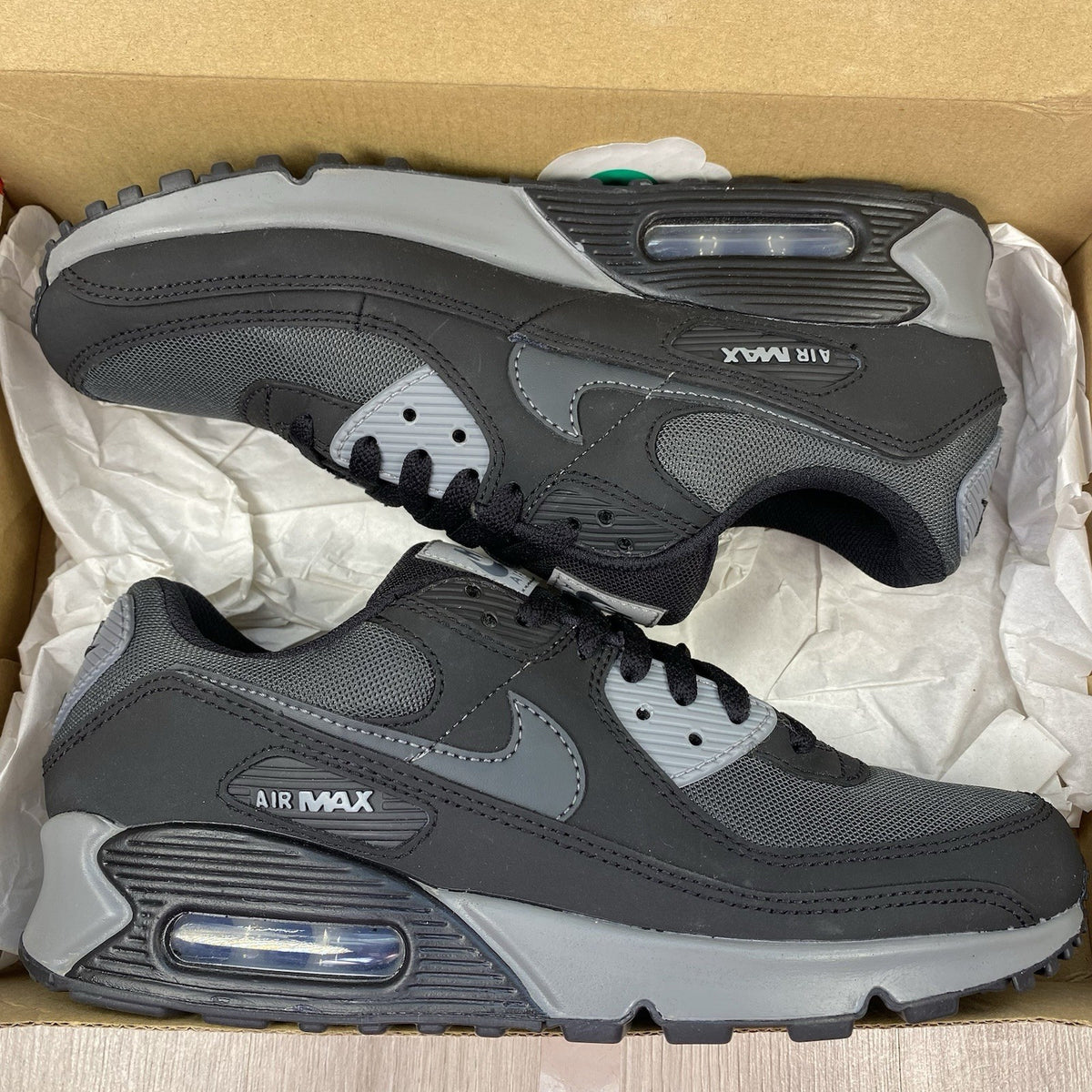 Nike Air Max 90 trainers black with anthracite and cool grey accents, featuring logo details.