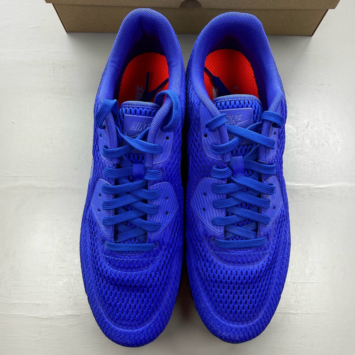 Nike Air Max 90 blue trainers with breathable mesh upper and signature swoosh logo.
