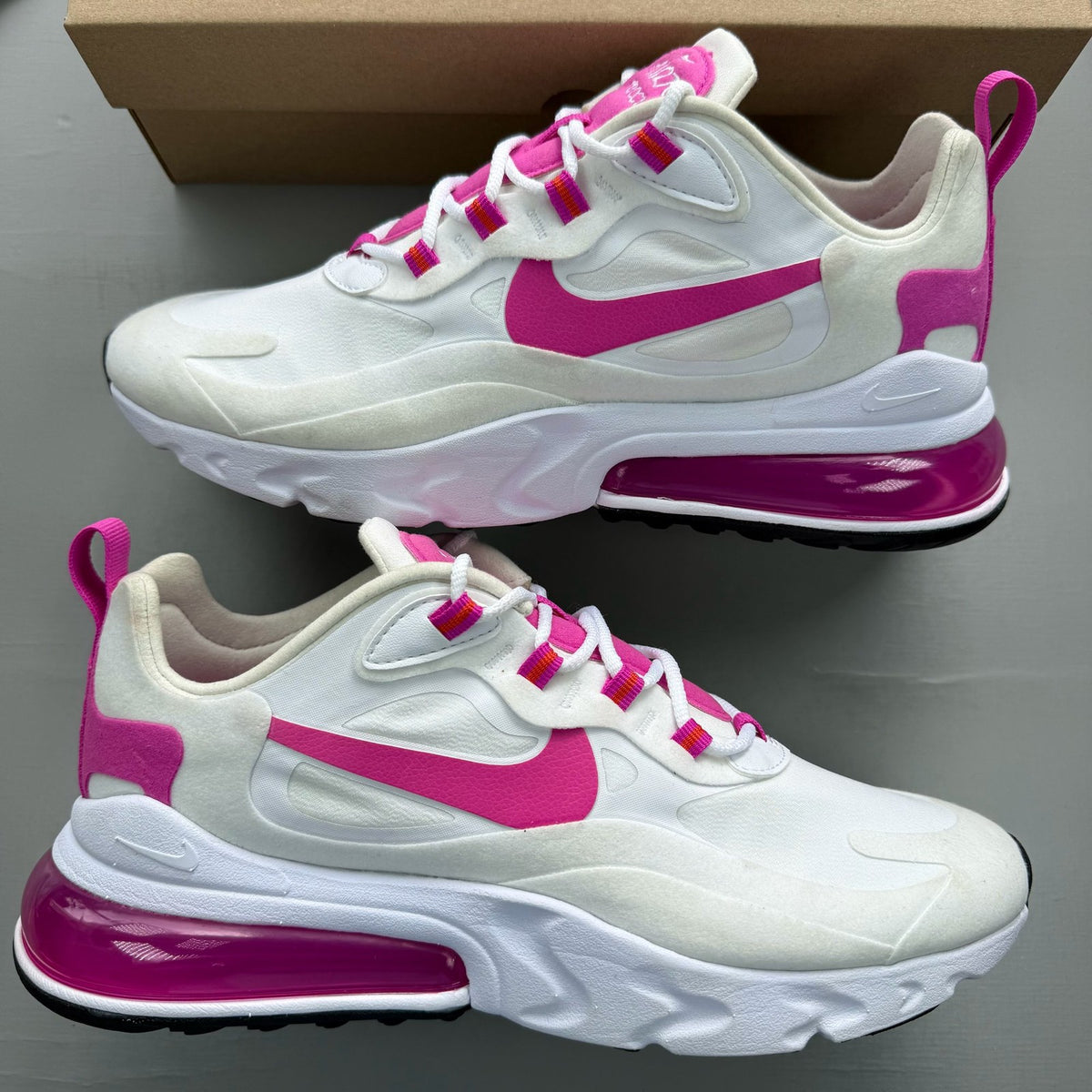 Nike white trainers with fire pink accents and Air Max logo detail.