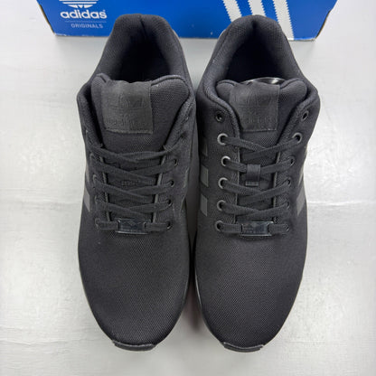 Adidas black trainers with iridescent accents and signature logo on tongue.