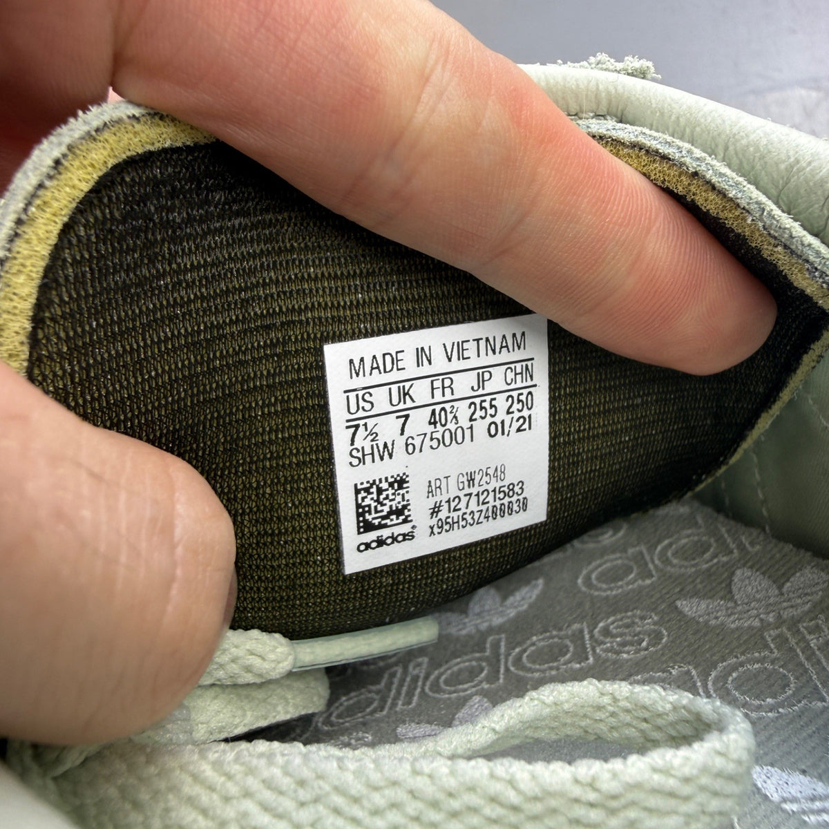 Adidas green deck shoes with white accents and logo detailing.