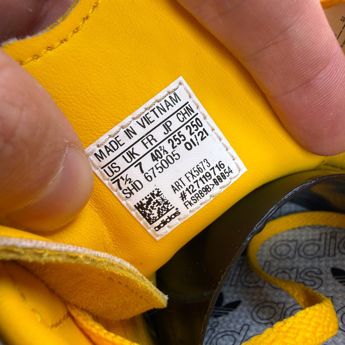 Adidas yellow trainers with black and gold accents, featuring iconic logo detail.