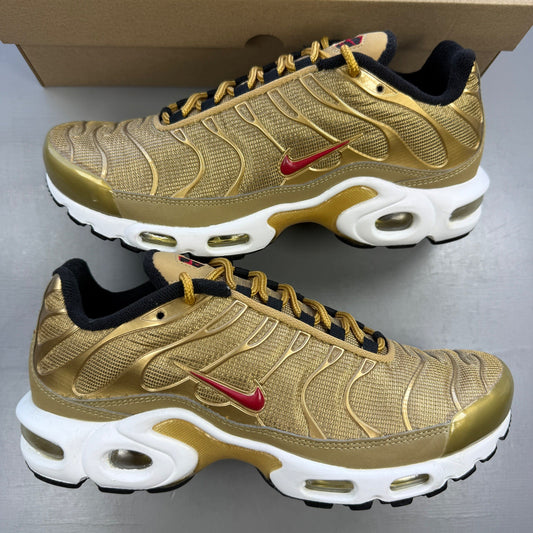 Nike gold trainers with metallic finish and distinctive Air Max Plus TN design.