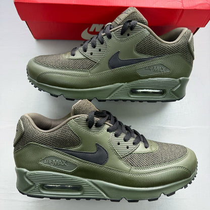 Nike Air Max 90 green trainers with black accents and logo detail.