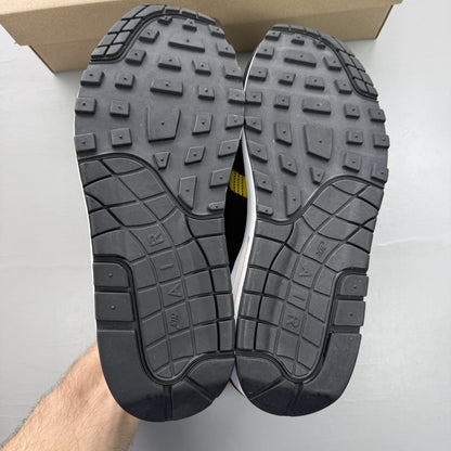 Nike Air Max 1 SE trainers black with tartan pattern and yellow accents.