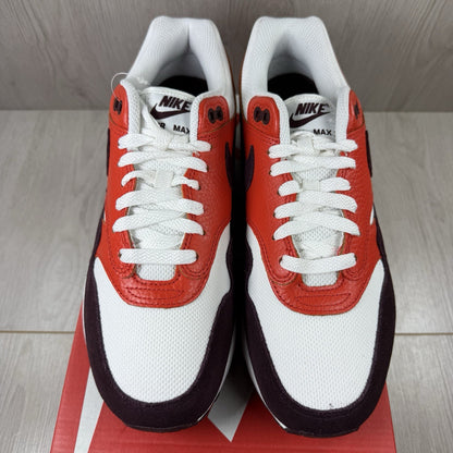 Nike Air Max 1 red trainers with white accents and signature swoosh logo.