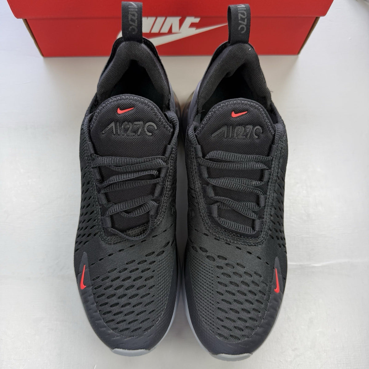 Nike Air Max 270 BG black trainers with crimson red accents and grey detailing.