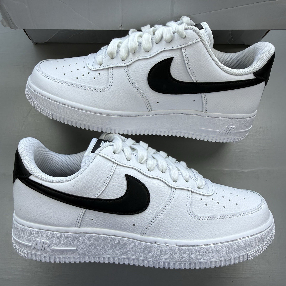 Nike Air Force 1 Low trainers white with black swoosh logo and leather upper.
