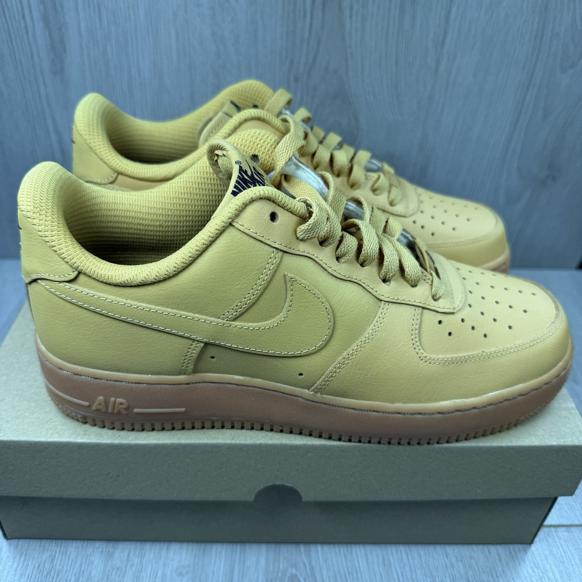 Nike Air Force 1 trainers brown suede upper with gum sole and logo detail.