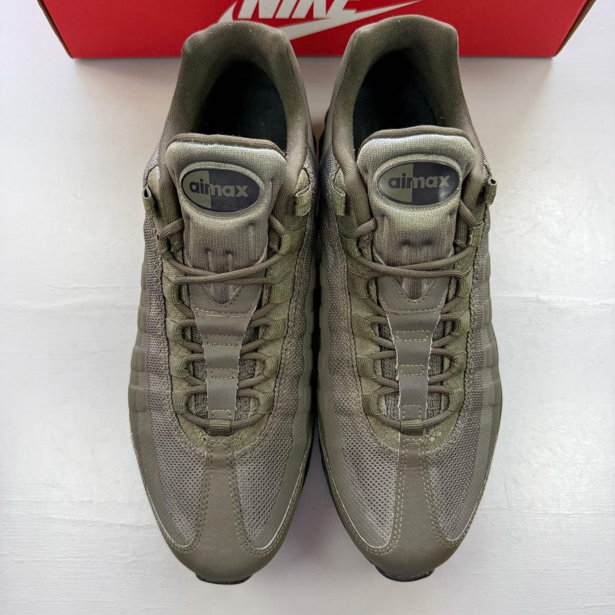 Nike Air Max 95 Ultra green trainers with black accents and logo details.