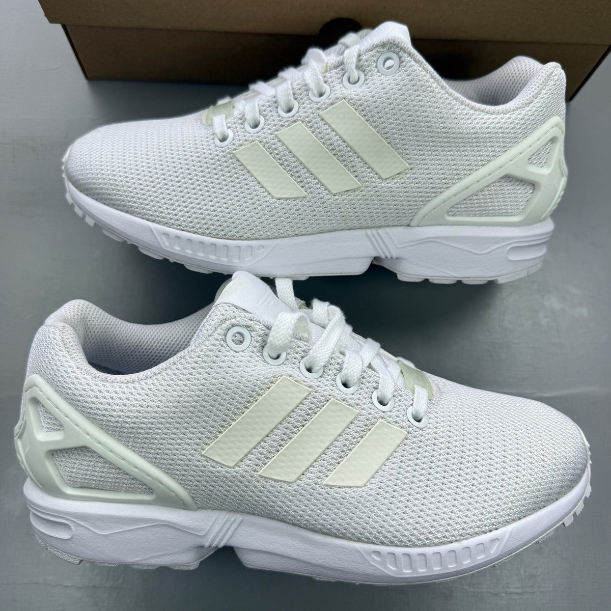 Adidas ZX Flux white running trainers with clear grey accents and minimalist design.