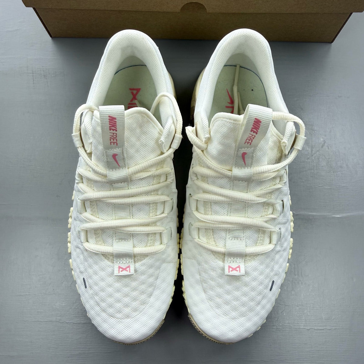 Nike white trainers with mesh upper and subtle branding details.
