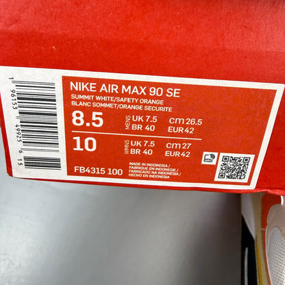 Nike Air Max 90 SE white trainers with orange accents and signature logo.