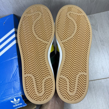 Adidas black trainers with yellow accents and classic three-stripe logo design.
