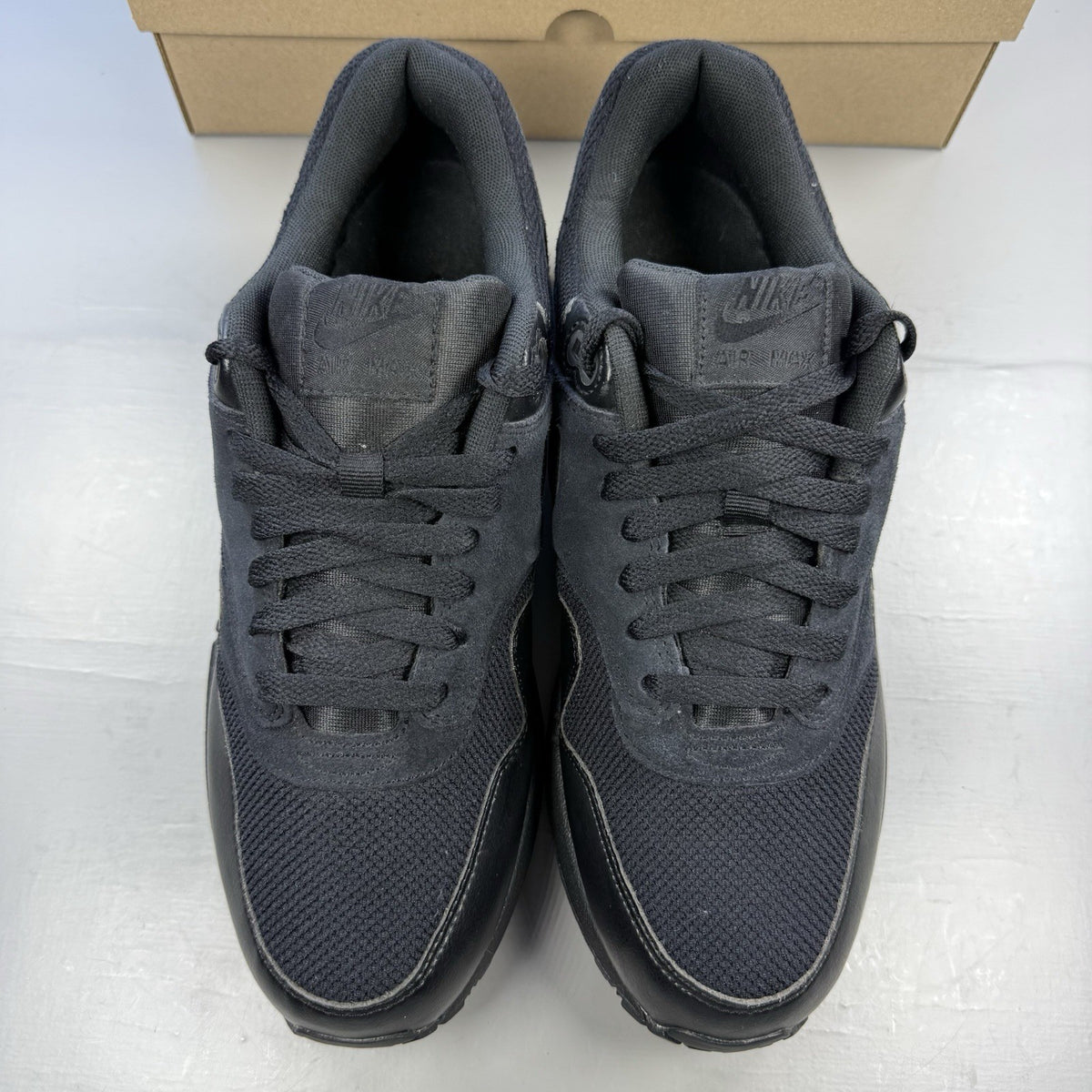 Nike black Air Max 1 Essential trainers with signature swoosh logo and mesh detailing.