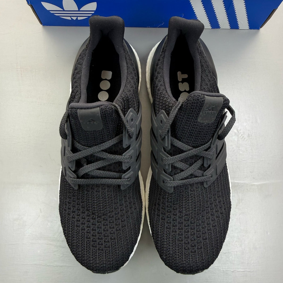 Adidas Ultra Boost 4.0 black running trainers with white accents and logo detail.