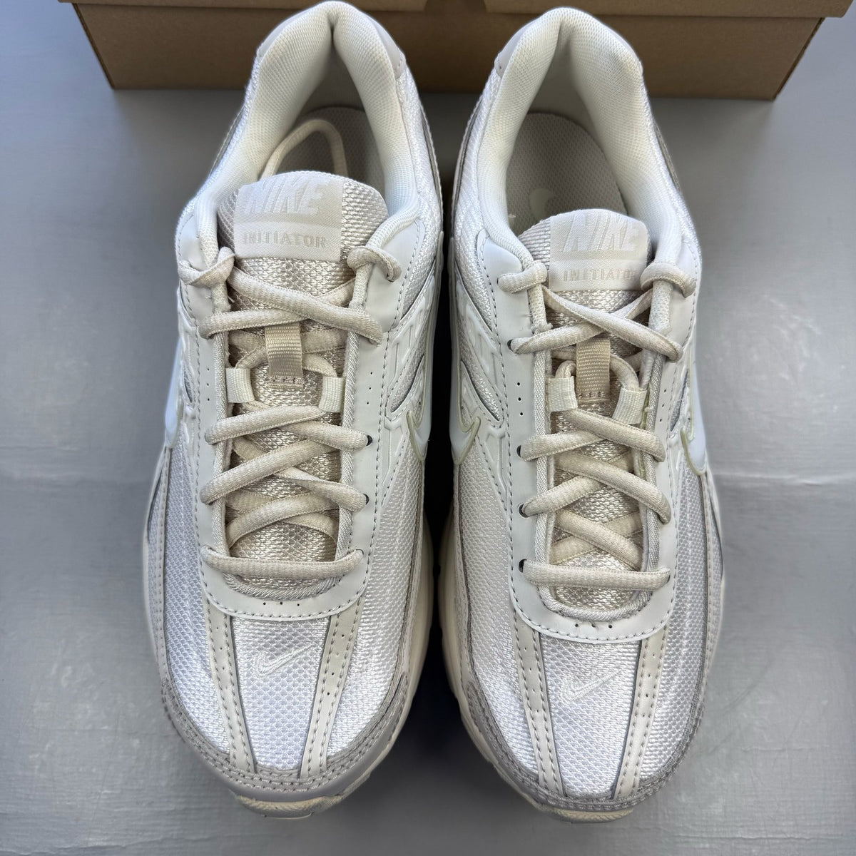 Nike white trainers with light orewood brown accents and swoosh logo.