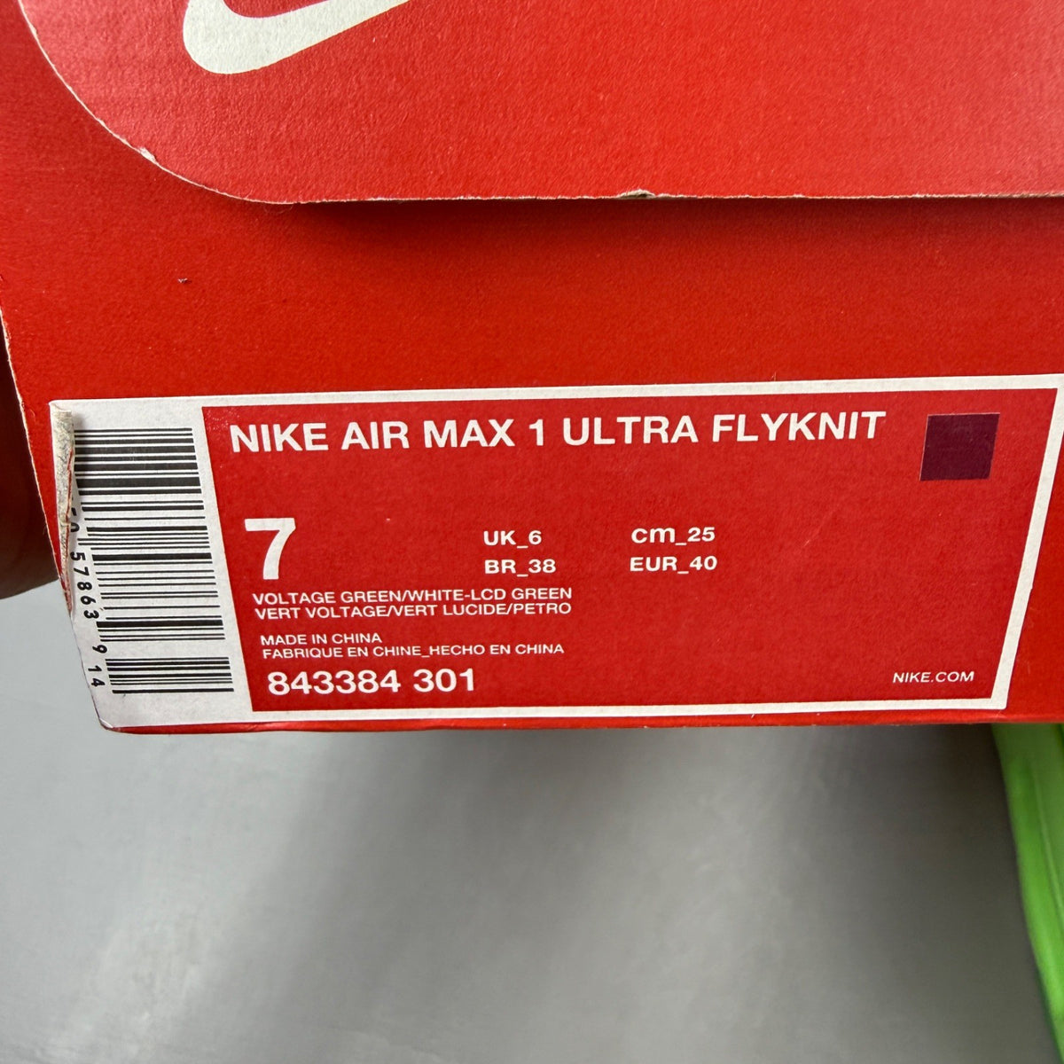 Nike trainers green Flyknit upper with Air Max cushioning and logo detail.