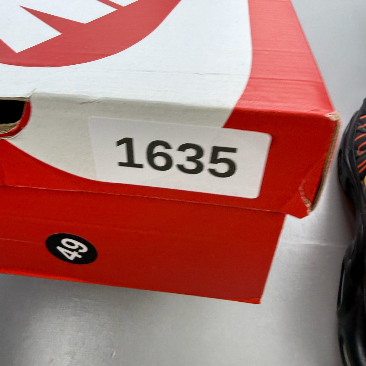 Nike black trainers with Tuned Air technology and sunrise pattern accents.