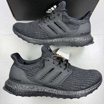 Adidas black trainers with grey accents and signature three-stripe logo.