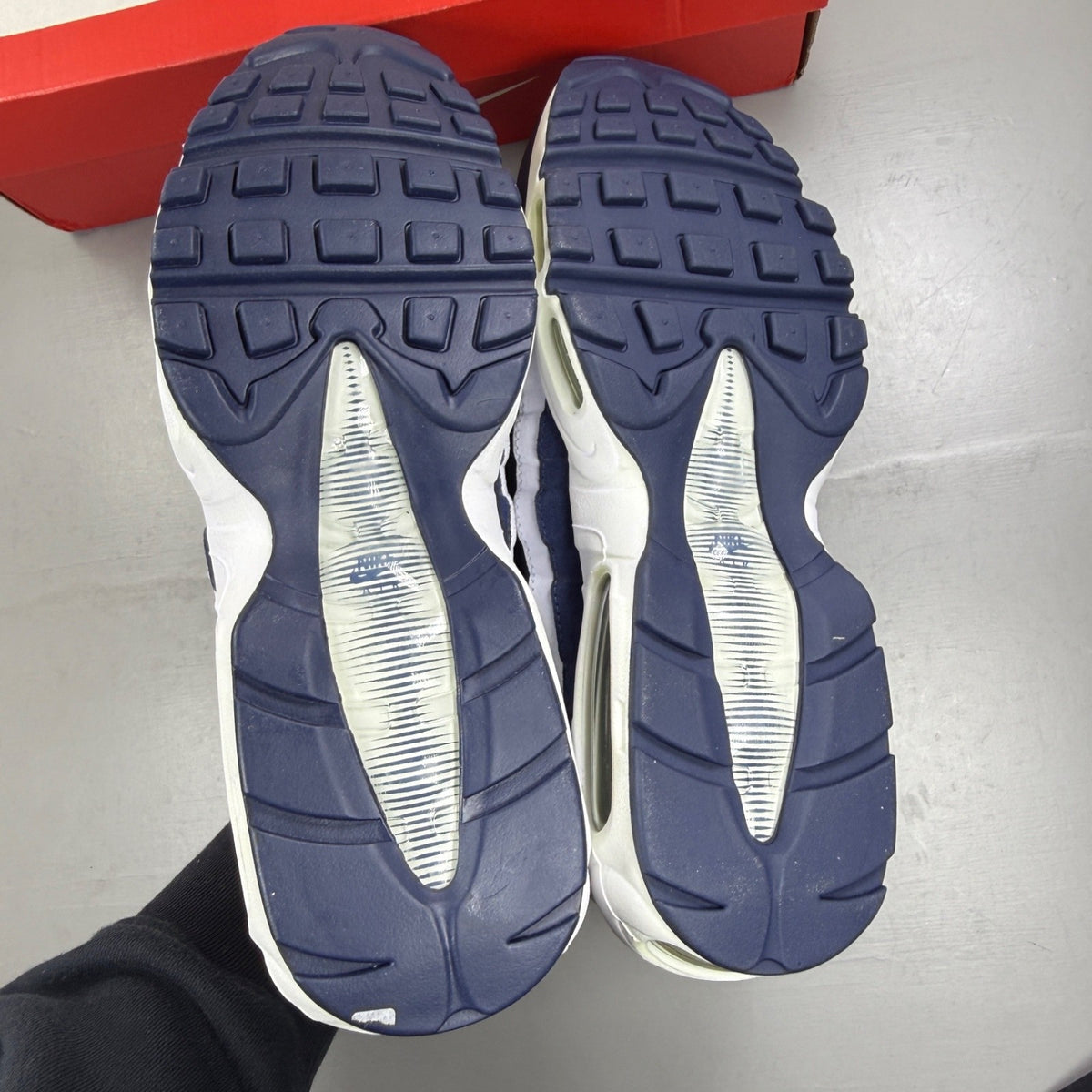 Nike Air Max 95 white trainers with navy accents and signature logo detailing.