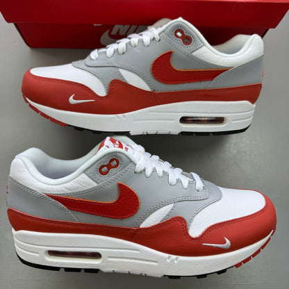 Nike Air Max 1 white trainers with grey accents and Martian Sunrise detailing.