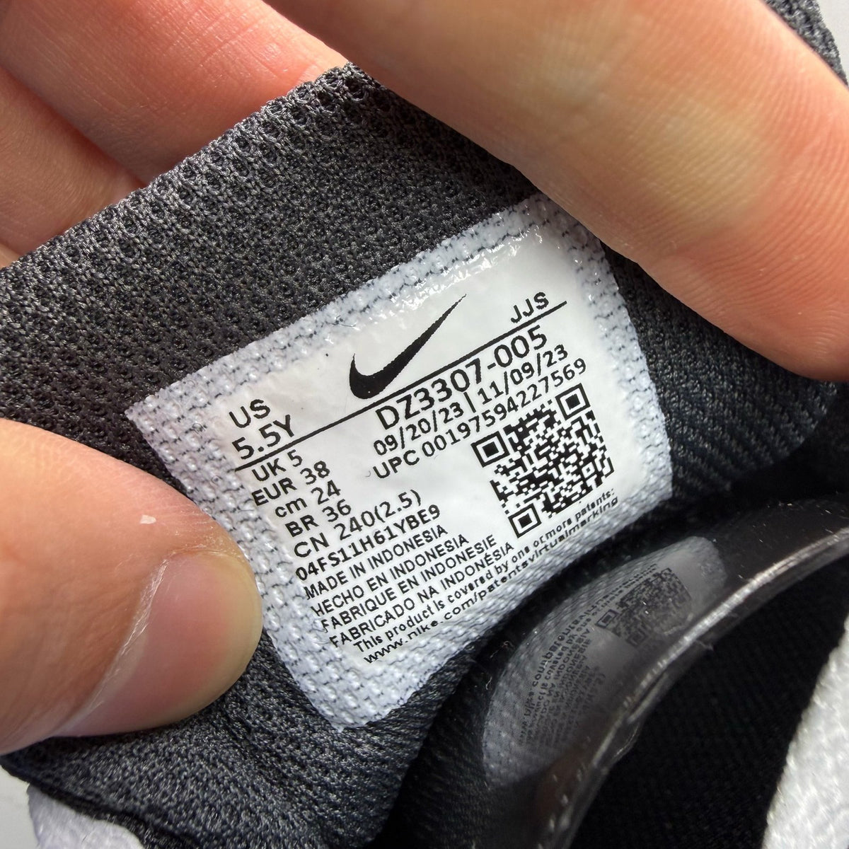 Nike Air Max 1 black trainers with silver and white accents, featuring iconic logo.