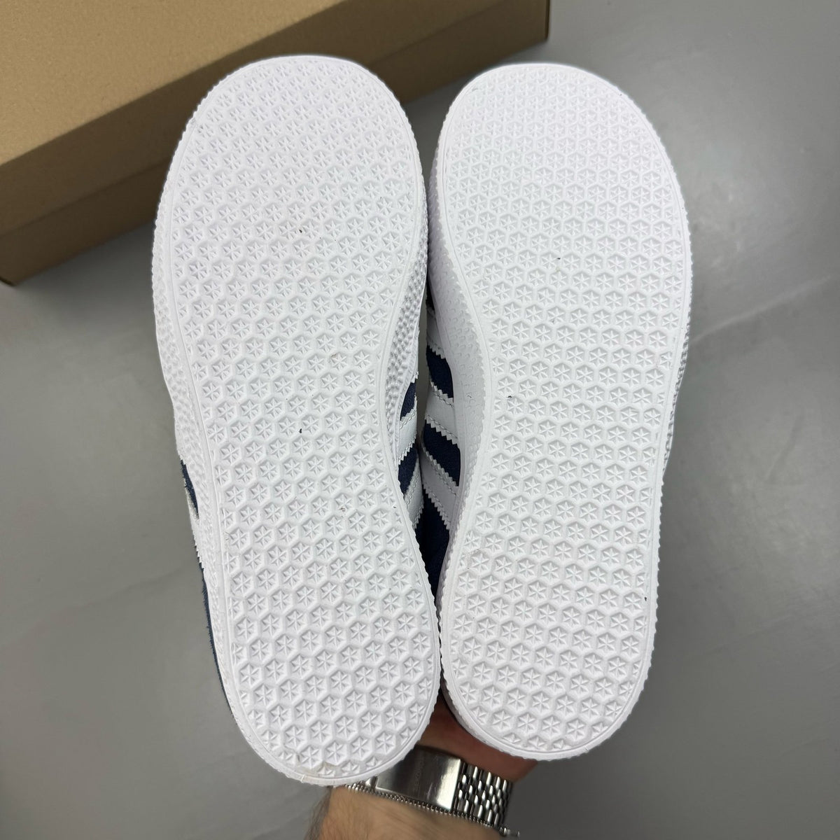 Adidas Gazelle blue trainers with white stripes and classic logo detail.