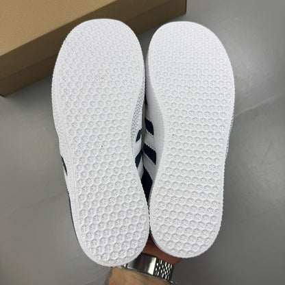 Adidas Gazelle blue trainers with white stripes and classic logo detail.