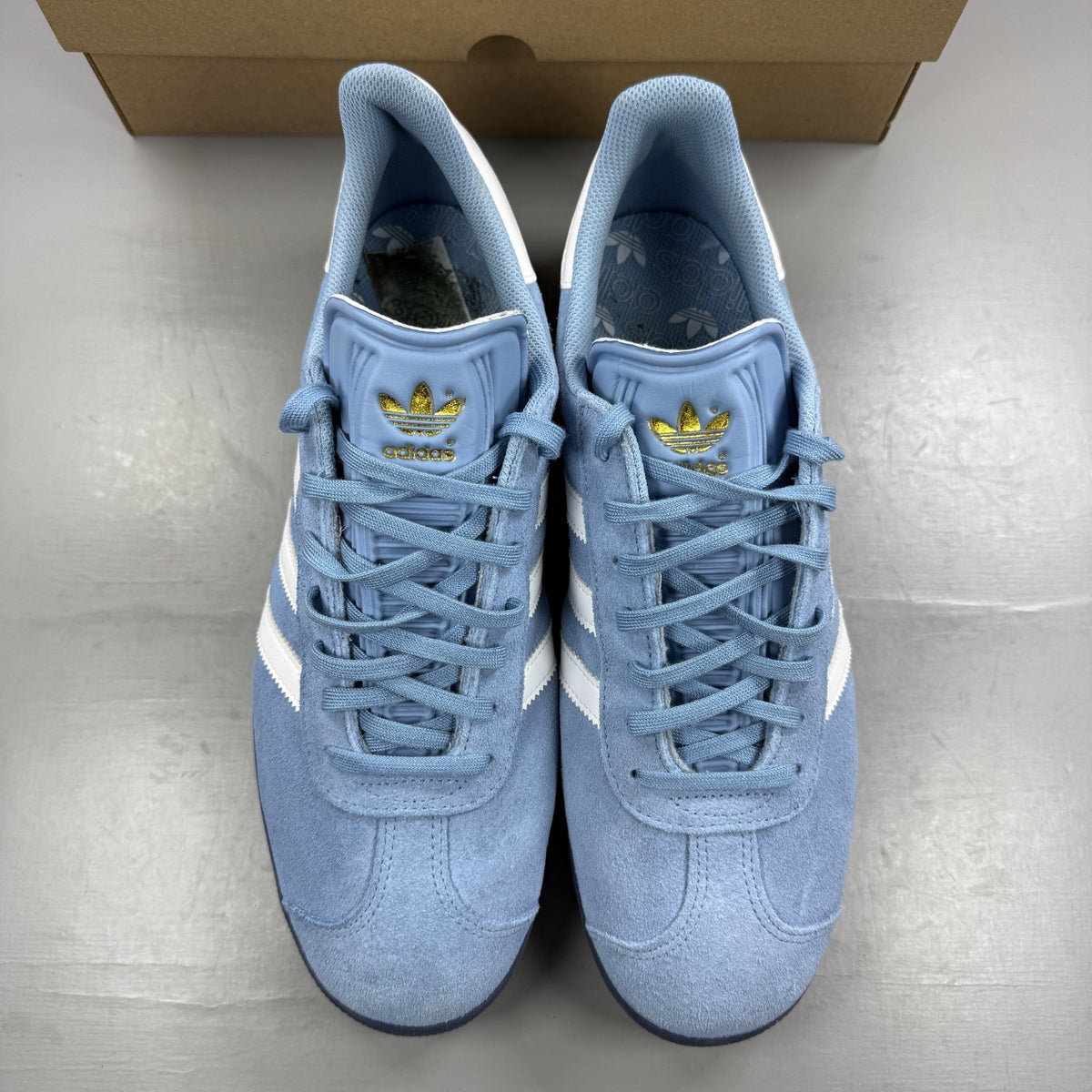 Adidas athletic shoes sky blue with white stripes and logo detail.