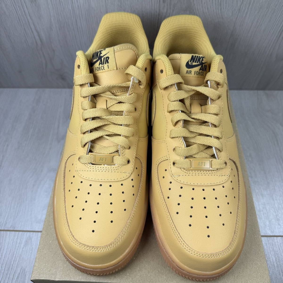 Nike Air Force 1 trainers brown suede upper with gum sole and logo detail.