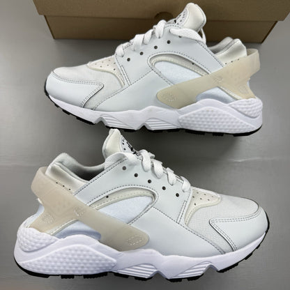 Nike black Air Huarache trainers with grey accents and textured mesh detailing.