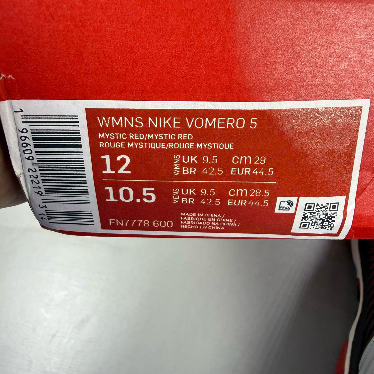 Nike Zoom Vomero 5 black trainers with red accents and white logo details.