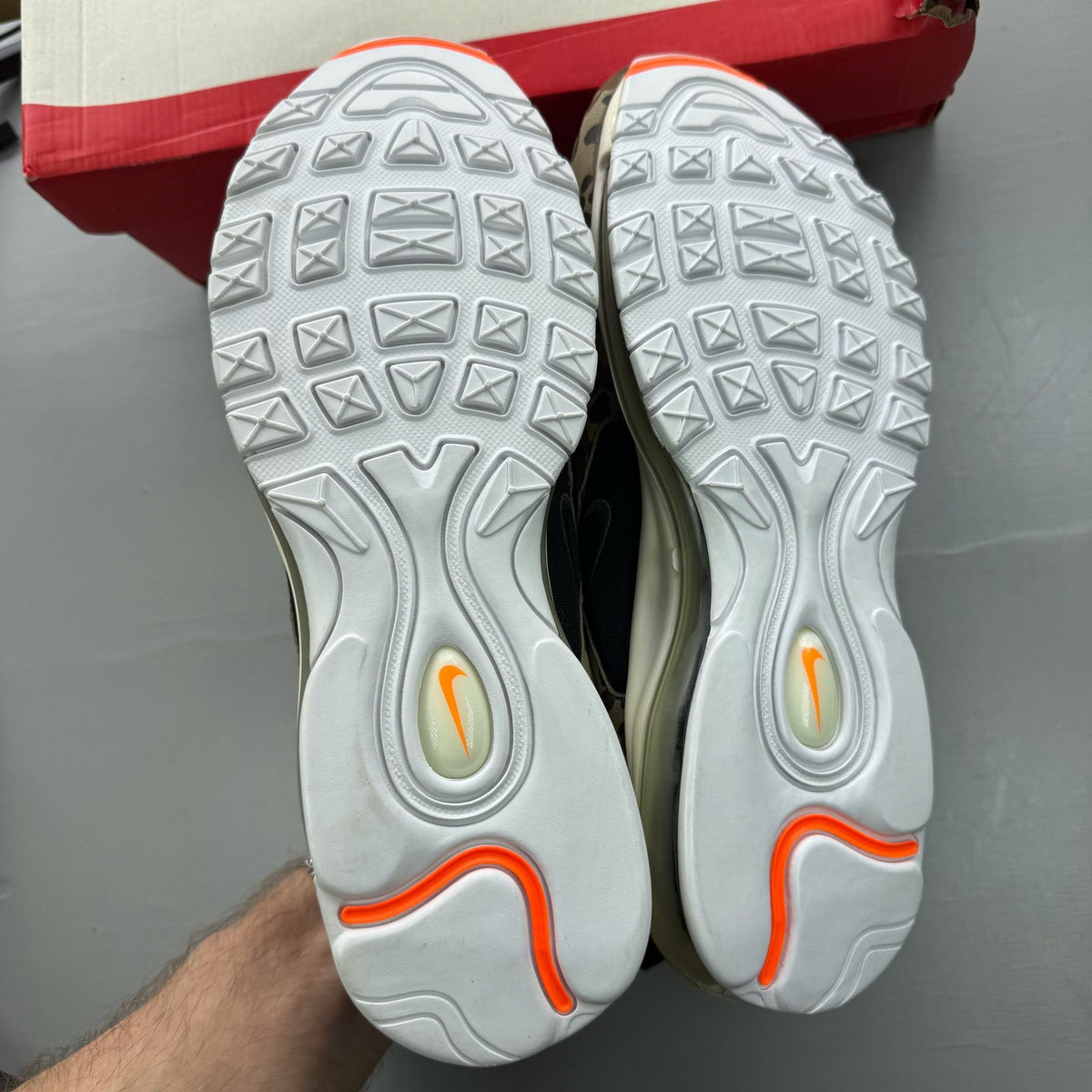 Nike black Air Max 97 trainers with country camo pattern and logo details.
