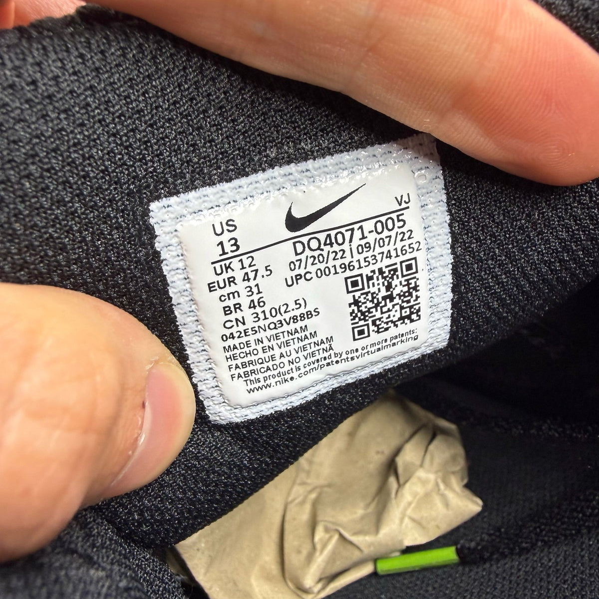 Nike Air Max 90 black trainers with green accents and logo detail on the tongue.