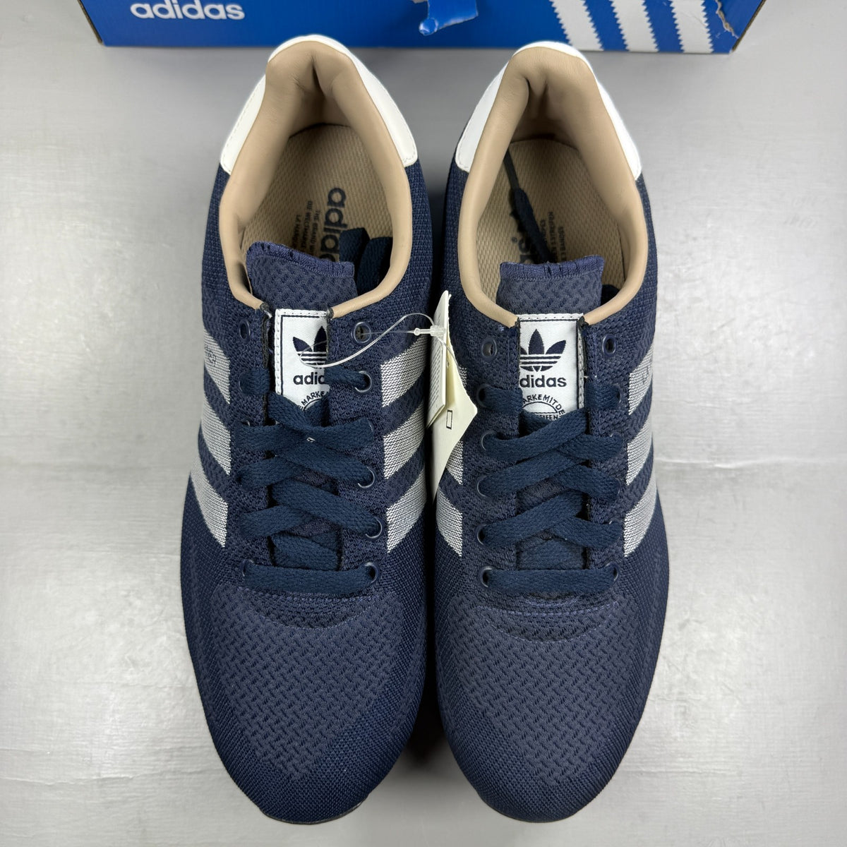 Adidas blue athletic shoes with white accents and textured weave design.