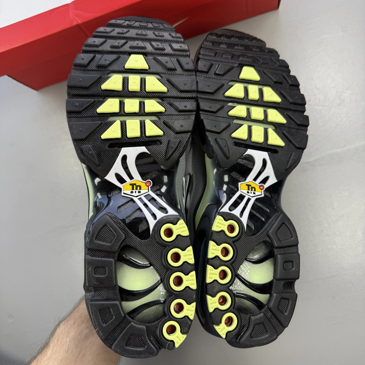 Nike Air Max Plus TN grey trainers with white and liquid lime accents, logo detail.
