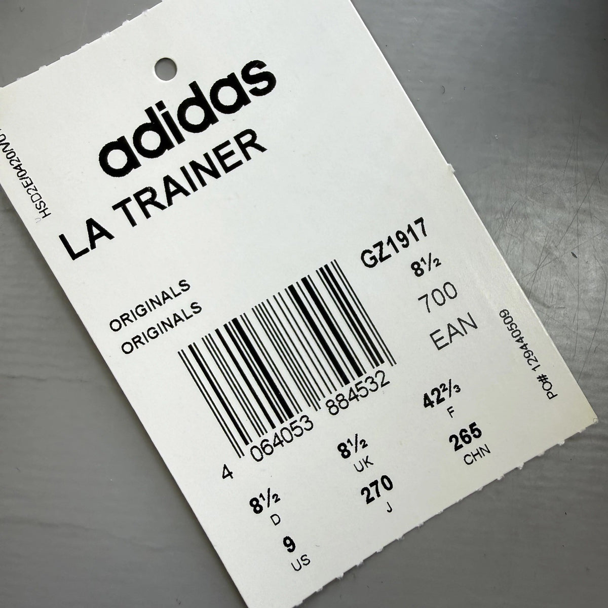 Adidas blue LA Trainer sneakers with white stripes and logo detailing.