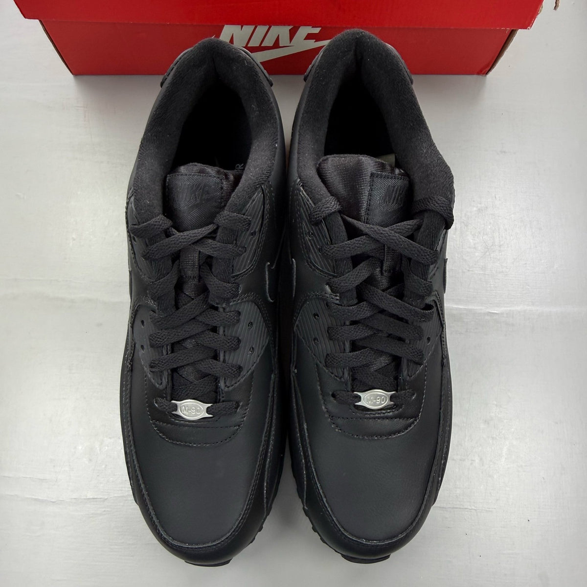 Nike black trainers leather upper with Air Max cushioning and logo detail.