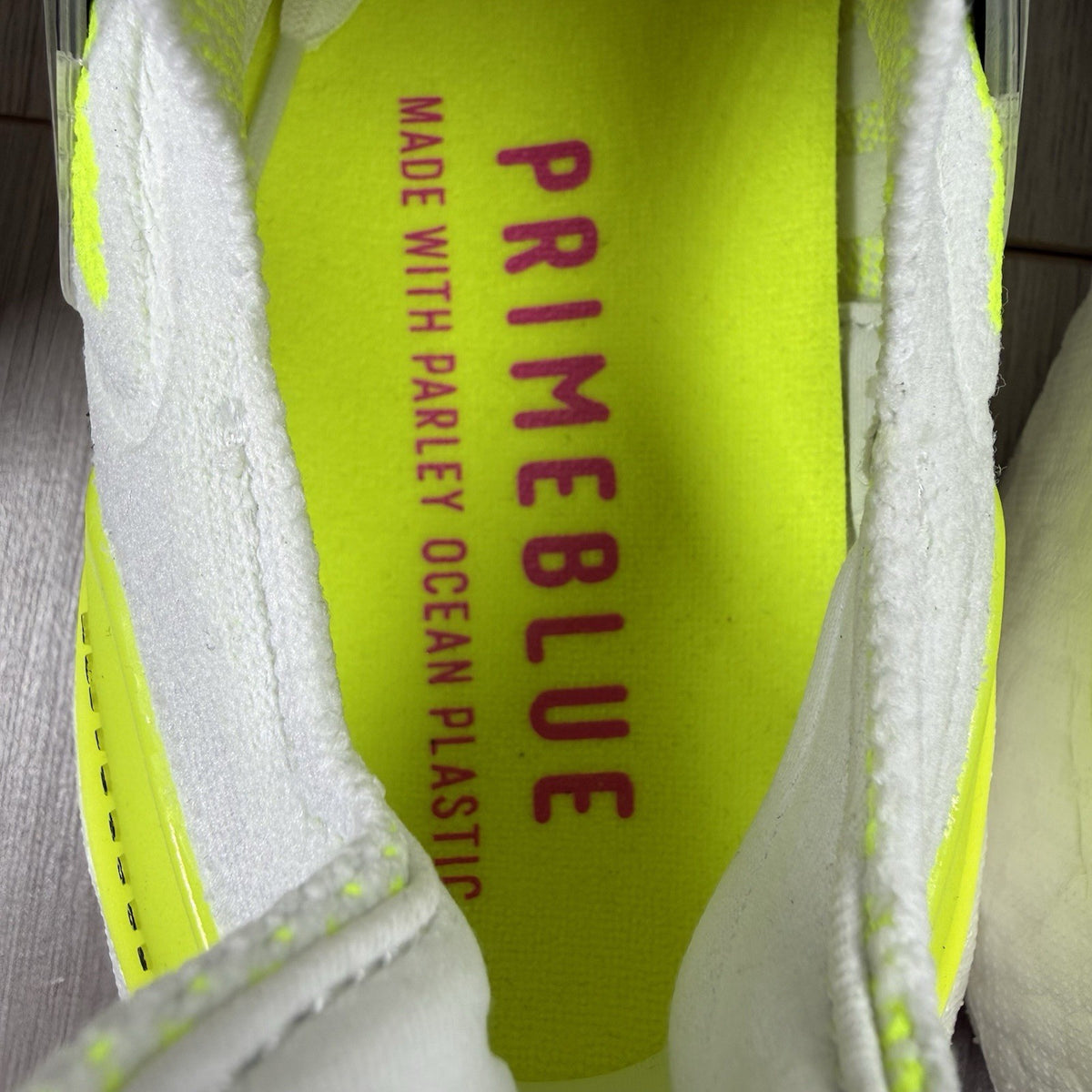 Adidas Ultra Boost 21 white trainers with solar yellow accents and signature three-stripe logo.