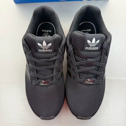 Adidas black trainers with sleek design and logo detail, perfect for kids.