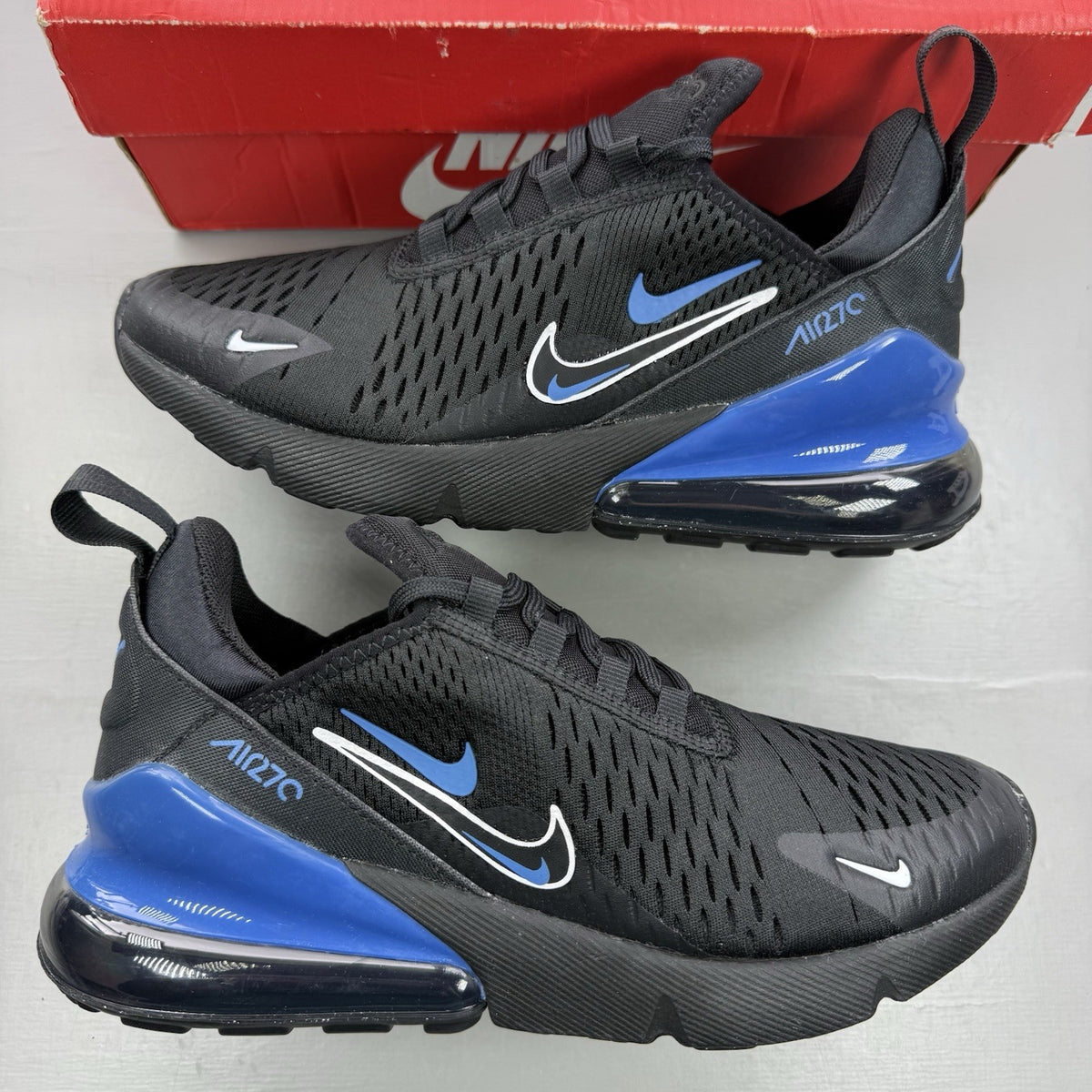 Nike Air Max 270 black trainers with multi-swoosh logo and Marina Blue accents.