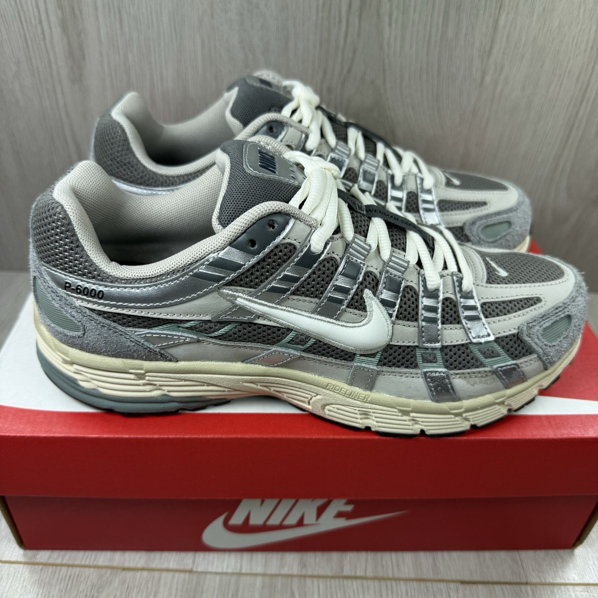 Nike grey P-6000 trainers with mesh upper and reflective detailing.